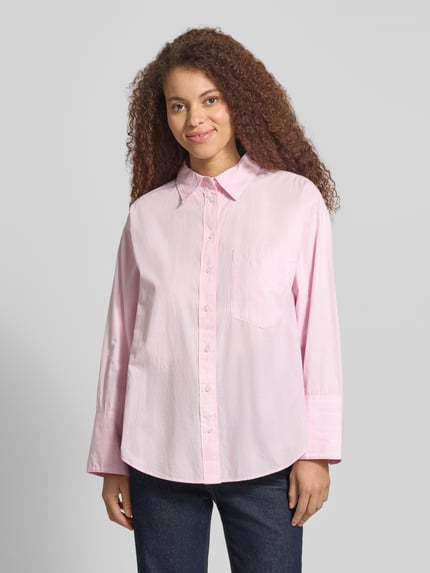 Modelka nosi Regular Fit Bluse mit Brusttasche von Gina Tricot z bawełny, kołnierzyk koszulowy, brustasza, listwa guzikowa, przód, całe ciało.