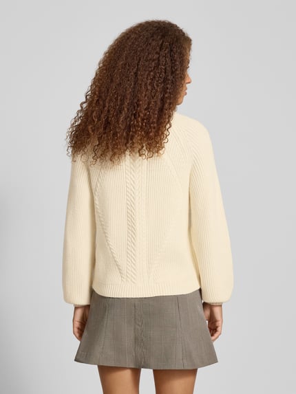 Frauenmodel trägt Regular Fit Strickpullover aus Viskose-Mix Modell 'KATIA' von Only, Zopfmuster, creme, Ganzkörperansicht Rückansicht.