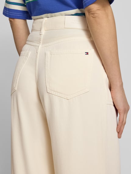 Frauenmodel trägt Wide Leg Jeans aus Lyocell von Tommy Hilfiger in Creme mit Label Patch und 5-Pocket-Design, Ganzkörperansicht Rückansicht.