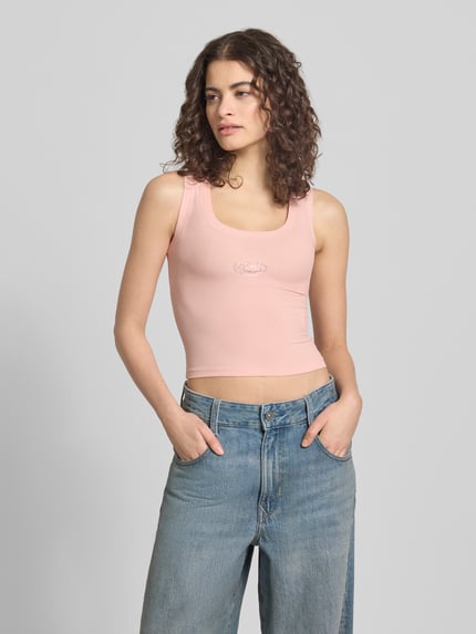 Kobiece modelka nosi Slim Fit Top mit Logo-Detail von ANOTHER COTTON LAB, jasnoróżowy, mieszanka bawełny, krój slim fit, okrągły dekolt, długość tyłu w rozmiarze S: 37 cm, widok całej sylwetki z przodu.