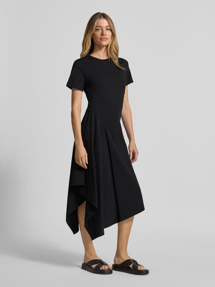 Männermodel trägt Tailliertes Jersey-Kleid aus Baumwoll-Mix von s.Oliver RED LABEL, schwarz, asymetryczny dół, krótki rękaw, Ganzkörperansicht von vorne.
