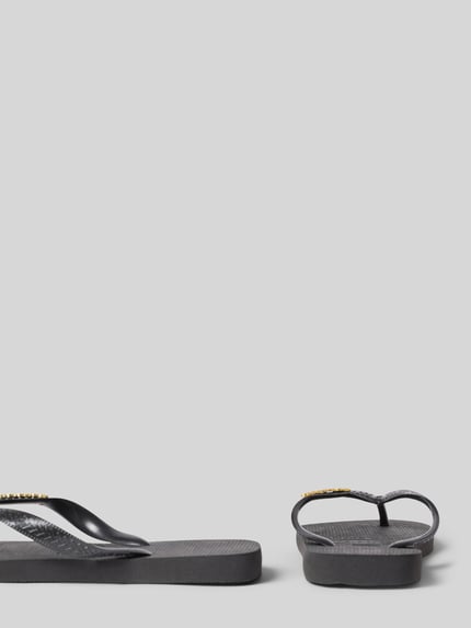 Produktfoto, Zehentrenner mit Label-Detail von Havaianas in Schwarz, flache Sohle, Schlupfform, Absatzhöhe 1 cm, strukturierte Oberfläche