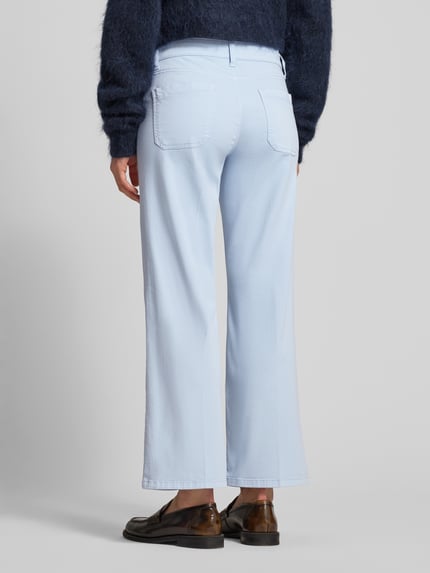 Frauenmodel trägt Cropped Jeans mit Bügelfalten und Eingrifftaschen von Cambio aus hellblauem Baumwoll-Mix mit Stretch, Ganzkörperansicht Rückansicht.