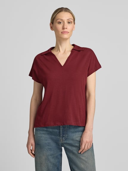 Frauenmodel trägt Regular Fit Poloshirt aus reiner Baumwolle von s.Oliver RED LABEL in Dunkelrot, lockere Form, Ganzkörperansicht von vorne.