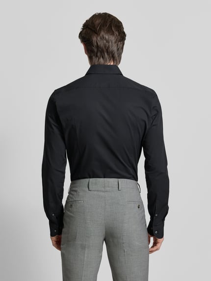 Männermodel trägt Slim Fit Businesshemd mit extra langem Arm von BOSS in Schwarz, Popeline-Baumwoll-Mix, Ganzkörperansicht Rückansicht.