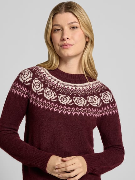 Frauenmodel trägt Pullover mit kontrastreichem Rundhals-Strickmuster von VERO MODA, mehrfarbig, Jacquard, florale und geometrische Muster, Feinstrick, gerippte Bündchen, Nahaufnahme Oberkörper.