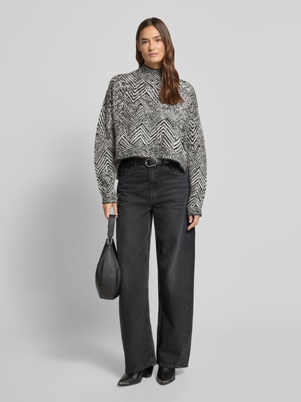Vrouwenmodel draagt Oversized Strickpullover aus Mohair-Woll-Mix Modell 'FACLINA' van BOSS met jacquard all-over patroon in zwart en grijs, lange mouwen, mock-neck, asymmetrische zoom, zichtbare structuur, Ganzkörperaanzicht van voren.
