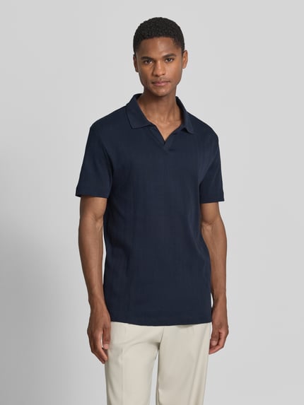 Männermodel trägt Regular Fit Poloshirt in Jaquard-Strick von Lindbergh in Dunkelblau, Reine Baumwolle, Polokragen, V-Ausschnitt, Label-Detail, Rückenlänge bei Größe M 73 cm, Ganzkörperansicht von vorne.