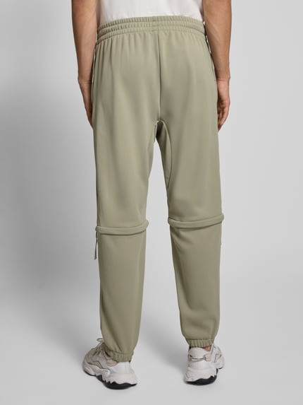 adidas Sportswear Spodnie dresowe o kroju relaxed fit z nadrukiem z logo Trzcinowy 5