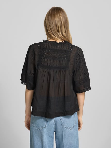 Frauenmodel trägt Blusenshirt mit V-Ausschnitt Modell 'Siama' von Neo Noir in Schwarz mit Stitchings, Regular-Fit, Rückenlänge 56 cm, Ganzkörperansicht Rückansicht.