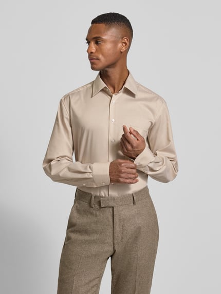 Männermodel trägt Comfort Fit Business-Hemd aus Baumwolle mit Kentkragen von ETERNA in Beige mit feiner Streifenstruktur, Nahaufnahme Oberkörper. Brusttasche, Knopfleiste, Rückenlänge 80 cm, Schulterbreite 48 cm, Ärmellänge 65 cm in Größe 40.