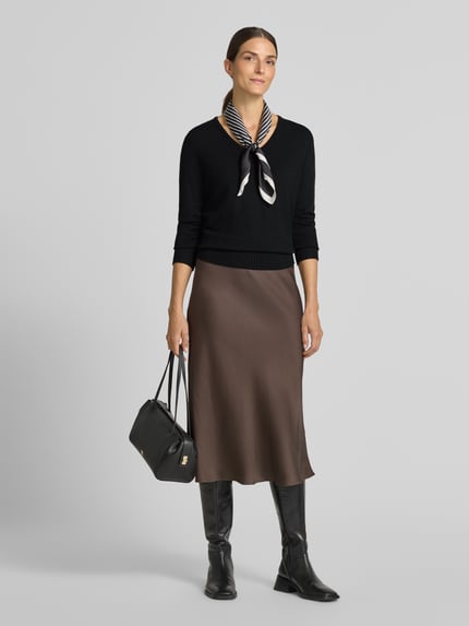 Vrouwenmodel draagt Regular Fit Sweatshirt aus Viskose-Anteil van Christian Berg Woman, Viscosemix, regular fit, v-hals, ribboorden, ruglengte maat S 63 cm, mouwlengte maat S 48 cm, zwart met bruine rok, Ganzkörperansicht von vorne.