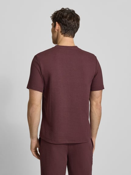 Männermodel trägt Regular Fit T-Shirt aus Baumwoll-Mix Modell 'AUSTIN' von HUGO in Unifarben mit Waffel-Struktur, Ganzkörperansicht Rückansicht.