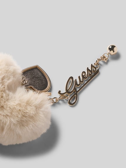 Produktfoto, Schlüsselanhänger mit Bommel Modell 'ALLEGRA' von GUESS in Beige mit goldfarbenem Label-Detail, samtige und metallische Texturen