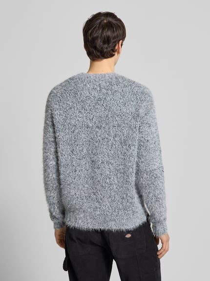Männermodel trägt Regular Fit Strickpullover mit Alpaka-Anteil Modell 'NOAH' von Only & Sons in grau melierter Optik, Ganzkörperansicht Rückansicht.