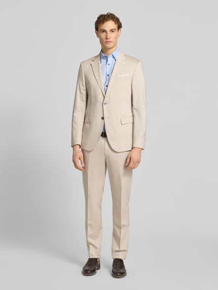 Männermodel trägt Slim Fit Business-Hemd mit Kentkragen von OLYMP Level Five in Hellblau, kombiniert zu beigem Anzug, Baumwoll-Elasthan-Mix, Knopfleiste, Ganzkörperansicht von vorne.