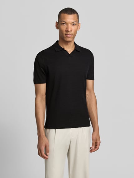 Männermodel trägt Modern Fit Poloshirt mit Polokragen und Label-Detail von MARKUP aus reiner Baumwolle, schwarze Farbe, Ganzkörperansicht von vorne. Rückenlänge bei Größe M: 70 cm.