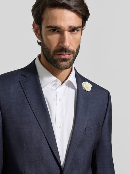 Männermodel trägt Slim Fit 2-Knopf-Sakko mit Zier-Detail von CG Club of Gents aus Schurwoll-Elasthan-Mix, Nahaufnahme Oberkörper.