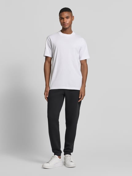 Männermodel trägt Sweatpants mit Viskose-Anteil Modell 'TRAIN PREMIUM SHIELD' von EA7 Emporio Armani, Gerade Passform, Ganzkörperansicht von vorne.