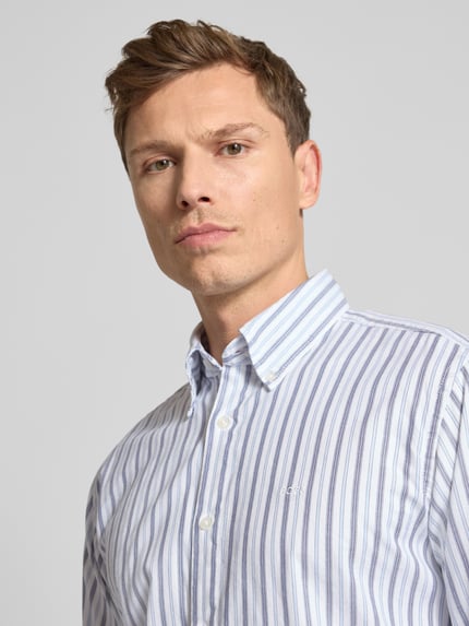 Männermodel trägt Slim Fit Freizeithemd aus Baumwoll-Mix Modell 'RICOPLUS_M' von BOSS Orange, gestreift, Nahaufnahme Oberkörper.