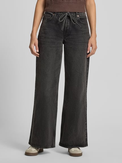 Frauenmodel trägt Wide & Loose Fit Jeans aus reiner Baumwolle Modell 'ASTRAEAAS' von ARMEDANGELS, dunkles Denim, lockerer Schnitt, Nahaufnahme Oberkörper, Damen Wide & Loose Fit Jeans von ARMEDANGELS.
