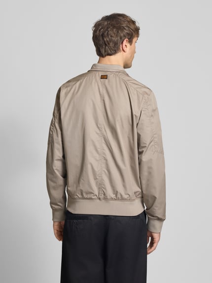 Männermodel trägt Jacke mit Stehkragen und Reißverschluss von G-Star Raw in Beige, Regular Fit, Baumwoll-Mix, Ganzkörperansicht Rückansicht.