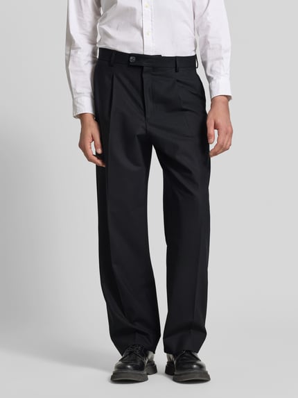 Männermodel trägt Straight Fit Stoffhose mit Bundfalten von ANNARR in Schwarz mit Eingrifftaschen, Ganzkörperansicht von vorne.