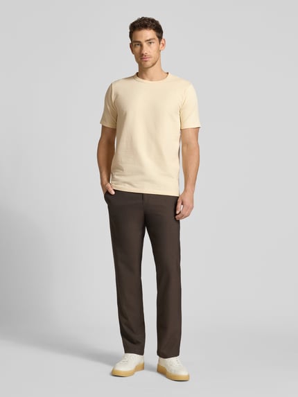 Männermodel trägt Regular Fit T-Shirt aus Baumwoll-Mix Modell 'SANDER' von SELECTED HOMME in Unifarben, Seersucker, Ganzkörperansicht von vorne.