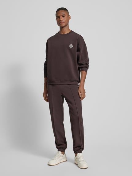 Männermodel trägt Regular Fit Sweatpants aus Baumwoll-Mix von Lacoste, Optik: Unifarben, Logo-Stitching, Piqué, Ganzkörperansicht von vorne.