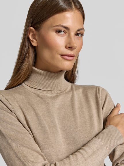 Vrouwenmodel draagt Slim Fit gebreide pullover uit Viscosemix Model 'Morla' van b.young in beige met col, elastische boorden, Nahaufnahme Oberkörper. Ruglengte maat S: 55 cm, mouwlengte maat S: 62 cm.