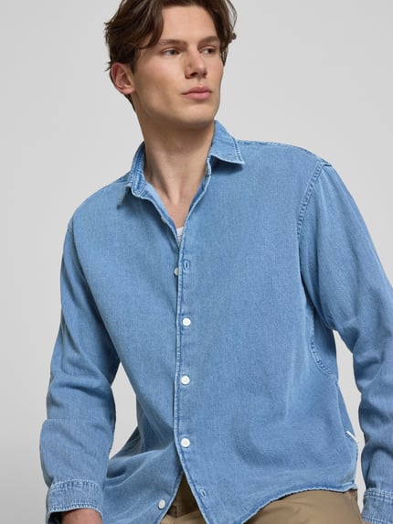 Männermodel trägt lichtblauw Regular fit heren jeanshemd van Jack & Jones model 'NORREBRO' van puur katoen met kentkraag en knoopsluiting, Nahaufnahme Oberkörper