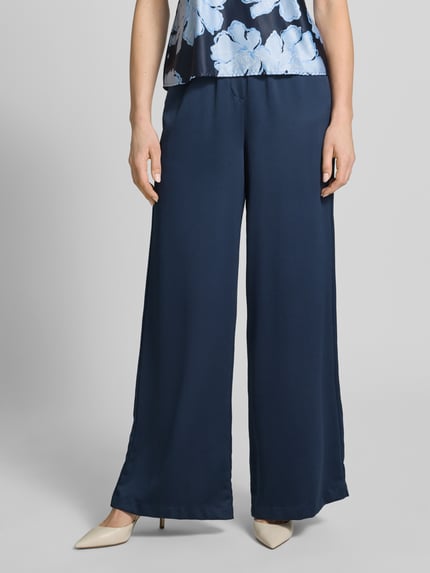 Frauenmodel trägt Loose Fit Pants mit elastischem Bund und Eingrifftaschen von Christian Berg Cocktail, navyblau, lockerer Schnitt, Nahaufnahme Unterkörper.