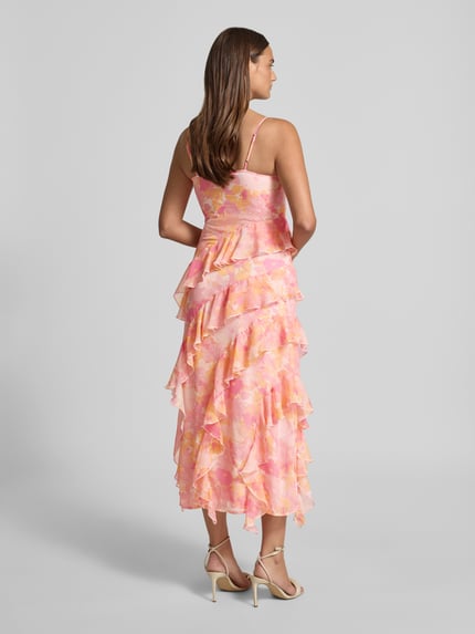 Frauenmodel trägt figurbetontes Midikleid mit Rüschen Modell 'SMILLA' von Vero Moda aus Chiffon mit Allover-Punktmuster in Rosa, Ganzkörperansicht Rückansicht
