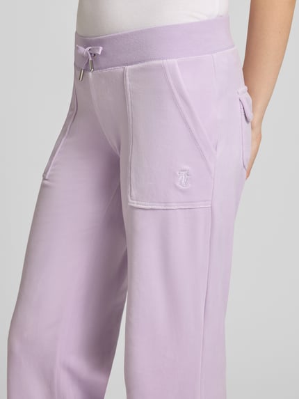 Frauenmodel trägt Low Rise Sweatpants mit Eingrifftaschen Modell 'LAYLA' von Juicy Couture in Lila, Material-Mix mit Stretch-Anteil, Nahaufnahme Oberkörper.