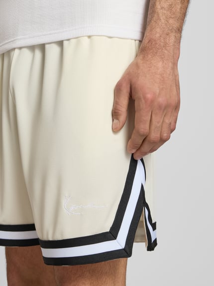 Männermodel trägt Regular Fit Shorts mit elastischem Bund von KARL KANI, Strukturmuster, Logo-Stitching, Nahaufnahme Oberschenkel.