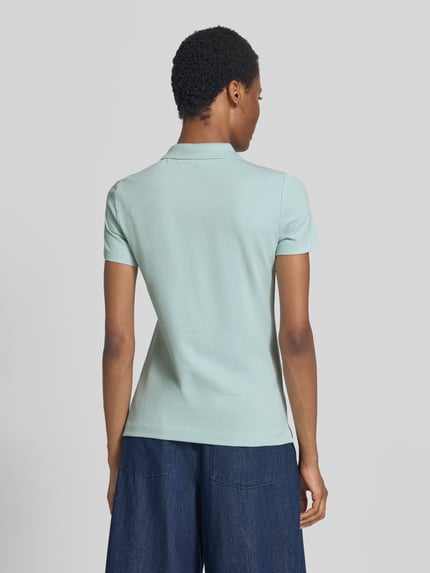 Frauenmodel trägt Regular Fit Poloshirt aus reiner Baumwolle von Tom Tailor in Hellblau, glatte Textur, Damen Poloshirt, Ganzkörperansicht Rückansicht.