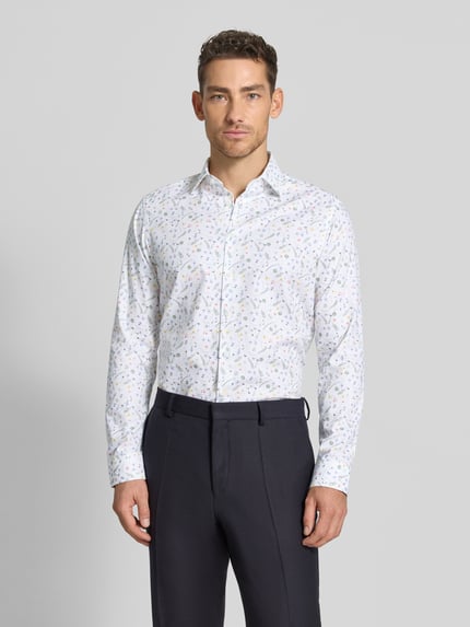 Männermodel trägt Regular Fit Business-Hemd aus Baumwolle mit Kentkragen von Christian Berg Men, Allover-Look, Ganzkörperansicht von vorne. Rückenlänge bei Größe 39/40: 68 cm, Schulterbreite: 43 cm, Ärmellänge: 66 cm, Reine Baumwolle.