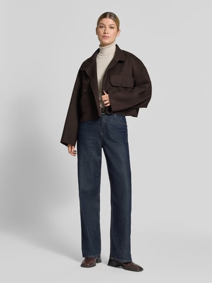Frauenmodel trägt Boxy Fit Jacke mit Stehkragen Modell 'ARKLOW' von DRYKORN im Baumwoll-Mix, dunkelbraun, Pattentaschen, Ganzkörperansicht von vorne.