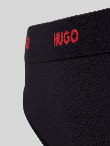 Kobiecy model nosi Stringi z mieszanki bawełny Model 'HUGO ID THONG' od HUGO, efekt: jednolity kolor, napis z logo, elastyczny ściągacz, mieszanka bawełny, detal: zbliżenie na biodro.