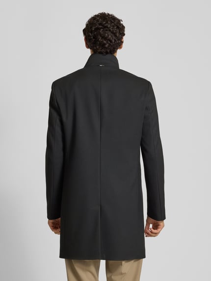 Männermodel trägt Slim Fit Mantel mit Viskose-Anteil Modell 'H-Hyde-SU' von BOSS, dunkle Farbe, glatte Textur, Ganzkörperansicht Rückansicht. Herren Mantel von BOSS.
