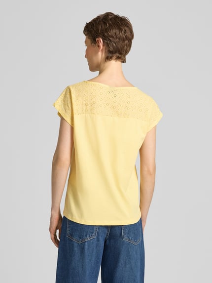 Vrouwenmodel draagt Regular Fit Blusentop uit puur katoen model 'JANNI' van Vero Moda, look: effen, semi-transparante garnering, boothals, korte mouw, jersey materiaalverwerking, Ganzkörperansicht Rückansicht.
