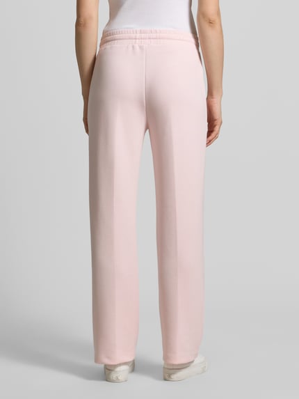 Frauenmodel trägt Sweatpants mit Label-Applikation Modell 'Talila' von JOOP! in Hellrosa, gerader Schnitt, elastischer Bund, Rückansicht