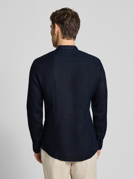 Männermodel trägt Slim Fit Leinenhemd mit Stehkragen Modell 'Mandarin' von SEIDENSTICKER in Dunkelblau, langärmelig, Rückenansicht. Reine Leinen, Brusttasche, durchgängige Knopfleiste, Rückenlänge 75 cm, Schulterbreite 39 cm, Ärmellänge 66 cm.