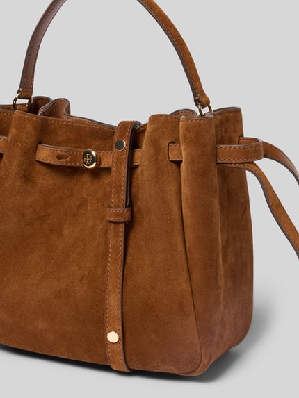 Productfoto, Bucket Bag in Suede-Optik van Tory Burch in warme bruine suèdelook met afneembare schouderband, magneetsluiting, logodetail, hoofdvak, breedte 23 cm, lengte 22 cm, diepte 10 cm.