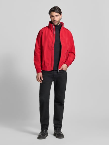 Männermodel trägt Regular Fit Jacke mit Kapuze Modell 'Como' von NAUTGÅRD in Rot, Zweiwegereißverschluss, Ganzkörperansicht von vorne.