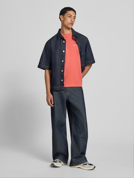 Männermodel trägt Regular Fit T-Shirt aus reiner Baumwolle Modell 'John Tee' von Pepe Jeans in Koralle, Ganzkörperansicht von vorne, Herren T-Shirt.