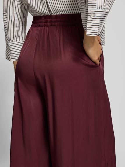 Frauenmodel trägt Weite Hose mit Tunnelzug von BOSS Orange, unifarbene Optik, elastischer Bundabschluss, gerippter Beinabschluss, Nahaufnahme Hüfte