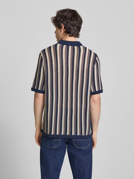 Męski model nosi Regular Fit Poloshirt aus Baumwoll-Mix Modell 'THUE' von Only & Sons, efekt: wzór w paski, ażurowa faktura, krótki rękaw, kołnierzyk polo, dekolt w serek, mieszanka bawełny, widok całej sylwetki od tyłu.