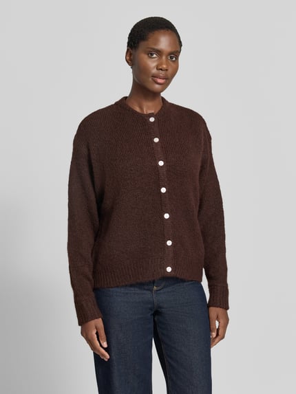Frauenmodel trägt Relaxed Fit Strickjacke mit Woll-Anteil Modell 'Belablue' von ICHI in Dunkelbraun, Rundhalsausschnitt, Knopfleiste, Strukturstrick, gerippte Bündchen, elastischer Material-Mix, langärmelig, Ganzkörperansicht von vorne.