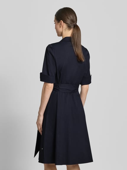 Frauenmodel trägt Knielanges Hemdblusenkleid mit Bindegürtel von ROBE LÉGÈRE in Dunkelblau, taillierter Schnitt aus Baumwoll-Mix mit Stretch-Anteil, Hemdblusenkragen, kurze Knopfleiste, Ärmel mit Aufschlag, Rückenlänge bei Größe 36: 104 cm, Brustweite 42 cm, Ärmellänge 30 cm, Ganzkörperansicht Rückansicht.